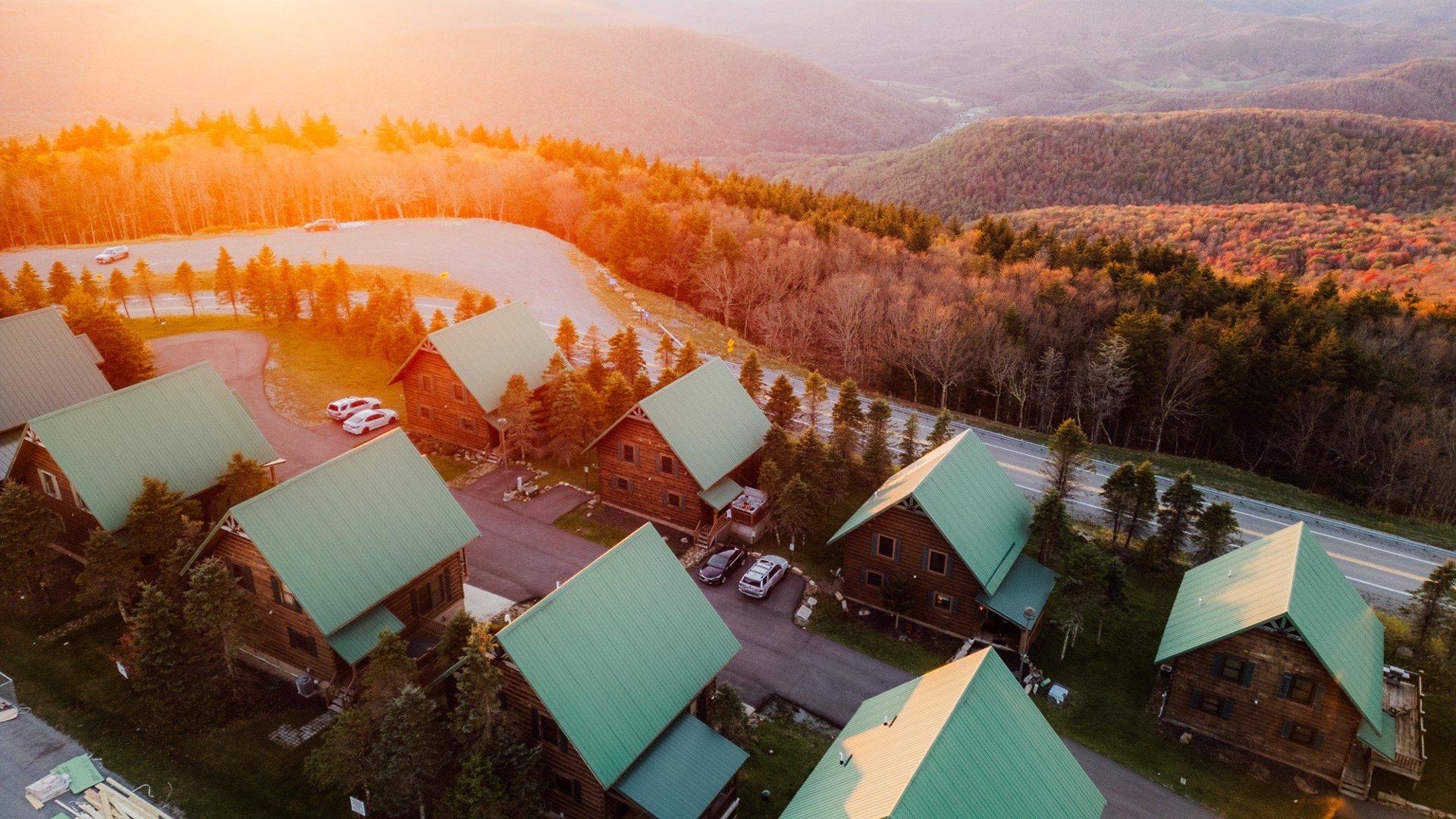 Snowshoe mountain homes at sunset from the air, fall color on the ridge behind them